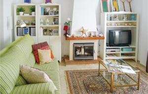 un soggiorno con divano verde e TV di Beautiful Apartment In Mezquitilla With Kitchen a Mezquitilla