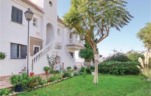 a house with a tree in the yard at Amazing Apartment In Mezquitilla With 1 Bedrooms in Mezquitilla