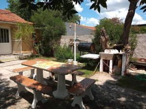 una mesa de picnic y dos bancos en un patio en Amplio depto para 4 personas a 1 cuadra del mar en Balneario Mar Chiquita