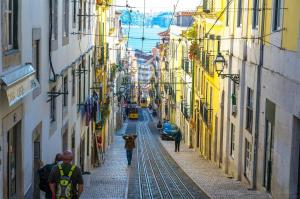 a group of people walking down a street between buildings at IN-Cascais Suite Deluxe com pátio privado in Cascais