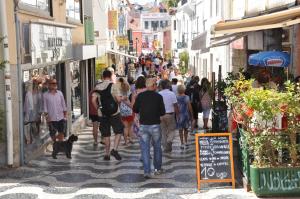 a group of people walking down a busy street at IN-Cascais Suite Deluxe com pátio privado in Cascais