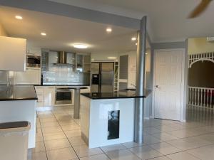 a large kitchen with black counter tops and appliances at SPECTACULAR WATERFRONT Canal Home, BRIBIE ISLAND in Banksia Beach