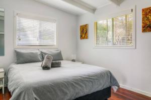 a bedroom with a bed with a cat laying on it at BEACHED @ YAMBA (water views, dog friendly, air con) in Yamba