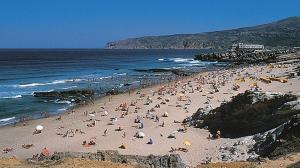 a group of people on a beach near the ocean at IN-Cascais Suite Deluxe com pátio privado in Cascais