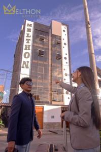 um homem e uma mulher em frente a um edifício em MELTHON URBANS em Ayacucho