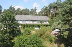 une maison au sommet d'une colline avec des arbres dans l'établissement Pension Zur Fledermaus, à Waren