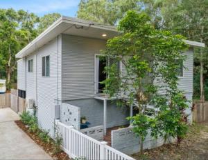 a small house with a white fence in front of it at Coastal Home, River & Surf Beach in New Brighton