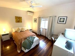 a bedroom with a bed and a window and a couch at Coastal Home, River & Surf Beach in New Brighton