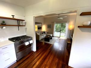 a kitchen with a stove and a living room at Coastal Home, River & Surf Beach in New Brighton