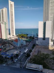 vistas a una ciudad con edificios y al océano en Lindo Apartamento com piscina à 100m do MAR, en Recife