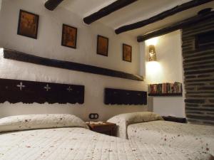 2 Betten in einem Schlafzimmer mit schwarzen und weißen Wänden in der Unterkunft Posá la Cestería in Baños de la Encina