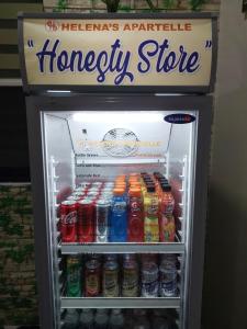 einen mit Getränken gefüllten Kühlschrank und ein Notrufzeichen in der Unterkunft Apartelle near Philippine Arena in Bulakan