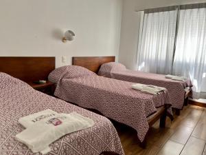 a hospital room with two beds with blankets at Hotel Lobato in Paysandú