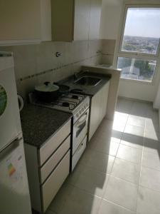 a kitchen with a stove and a sink and a window at A estrenar Parque del Sur in Santa Fe