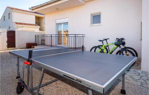 een tafeltennistafel voor een gebouw met een fiets bij Cozy Home In Gorica With Outdoor Swimming Pool in Gorica
