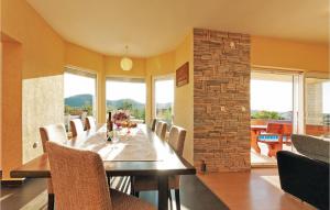 een eetkamer met een tafel, stoelen en ramen bij Cozy Home In Gorica With Outdoor Swimming Pool in Gorica