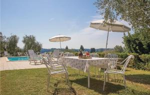 stół z krzesłami i parasolami przy basenie w obiekcie Nice Apartment In Marti Pi With Wifi w mieście Marti