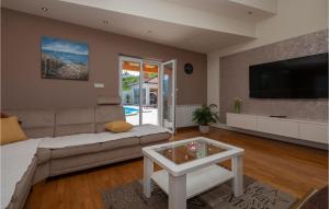 a living room with a couch and a tv at Lovely Home In Vrgorac With Jacuzzi in Vrgorac