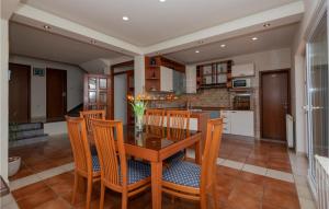 a kitchen and dining room with a wooden table and chairs at Lovely Home In Vrgorac With Jacuzzi in Vrgorac