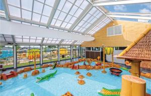 une grande piscine intérieure avec un toboggan dans l'établissement Het Rivierhuis, à Maurik