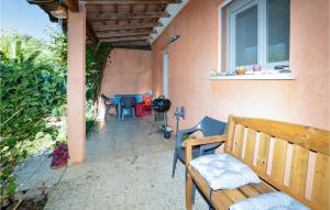 eine Terrasse mit einer Holzbank und einem Tisch in der Unterkunft Awesome Home In Cervione With Wifi in Cervione