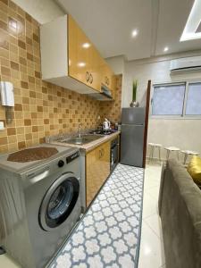 uma cozinha com uma máquina de lavar roupa e um lavatório em Geil Wohnung in Agadir Zentrum Haut founty em Agadir