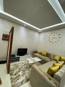 uma sala de estar com um sofá e um relógio na parede em Geil Wohnung in Agadir Zentrum Haut founty em Agadir
