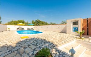 a swimming pool in a yard with a stone patio at Nice Home In Podgradina With 3 Bedrooms, Wifi And Outdoor Swimming Pool in Gradina