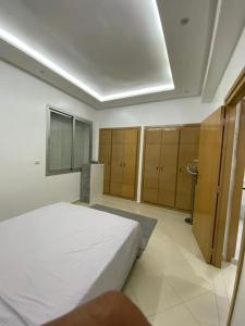 アガディールにあるGeil Wohnung in Agadir Zentrum Haut fountyの白いベッドとキャビネット付きのベッドルーム1室が備わります。