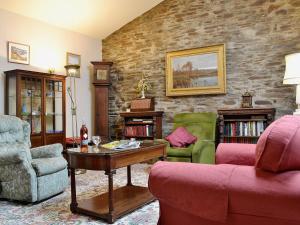 a living room with two chairs and a table at Violet Cottage in Llannon