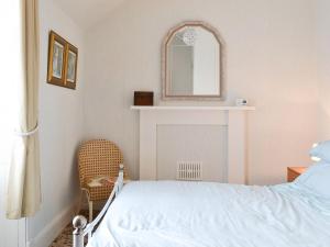 ウィックにあるMoray Cottageのベッドルーム1室(ベッド1台、鏡、椅子付)