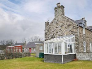 a brick house with a conservatory on the side of it at Moray Cottage in Wick