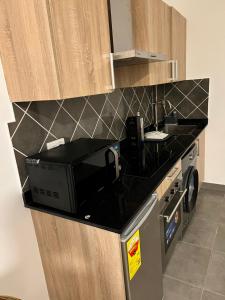 a kitchen with a black counter top and a microwave at The Moonlight Manor Suite in Accra