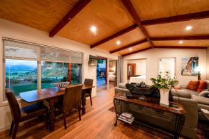 Criffel Bluffs Cottage في واناكا: غرفة معيشة مع طاولة وأريكة