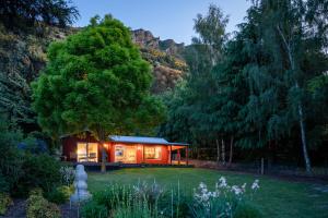 a small cabin in the middle of a garden at Criffel Bluffs Cottage in Wanaka