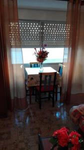 a room with a table with a vase of flowers on it at Apartamento Guardamar 1D Estándar in Guardamar del Segura