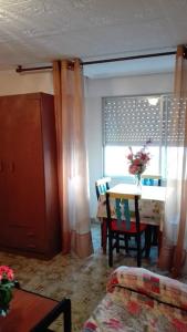 a living room with a table and a chair and a window at Apartamento Guardamar 1D Estándar in Guardamar del Segura