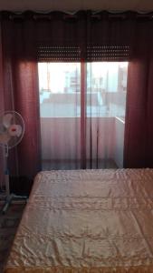 a bedroom with a bed and a window with a fan at Apartamento Guardamar 1D Estándar in Guardamar del Segura