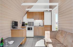 a kitchen with wooden cabinets and a couch in a room at Lovely Home In Hadsund With Wifi in Hadsund