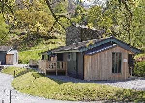 a small cabin with a porch in the grass at Hartsop Fold in Patterdale