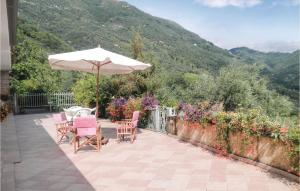 un patio con tavolo, sedie e ombrellone di Holiday Home Locmansana,Il Ceppo a Montemagno