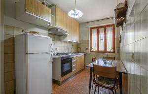 una cucina con un frigorifero bianco e un tavolo con sedie di Holiday Home Locmansana,Il Ceppo a Montemagno Altre 13 foto