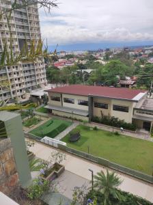 un edificio con un césped verde delante de él en COZY PLACE TO RELAX VERDON PARC en Davao