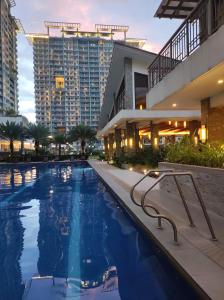 a large swimming pool in front of a building at COZY PLACE TO RELAX VERDON PARC in Davao City