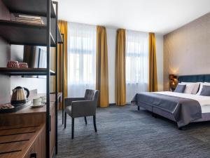 um quarto de hotel com uma cama e uma cadeira em Old Market Residence na Cracóvia