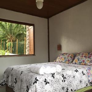 um quarto com uma cama e uma janela em Pousada da Preguiça Praia do Forte na Praia do Forte