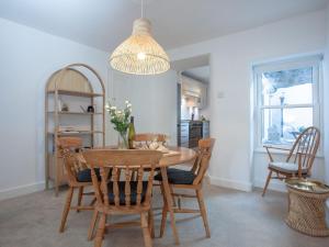 een eetkamer met een houten tafel en stoelen bij The Lookout 43 in Brixham