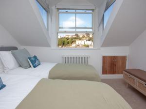 een slaapkamer met 2 bedden en een raam bij The Lookout 43 in Brixham
