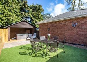 a patio with a table and chairs on the grass at Stunning Home In Axminster W- in Axminster