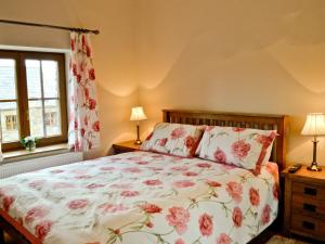 a bedroom with a bed with a floral bedspread at The Mill - Om3 in Mydroilin